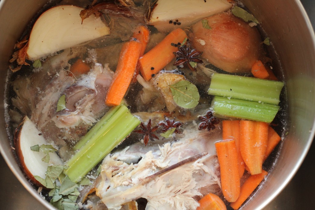 the makings for a good chicken stock - bones and veggies. oh, the delicious chicken soup it'll make!