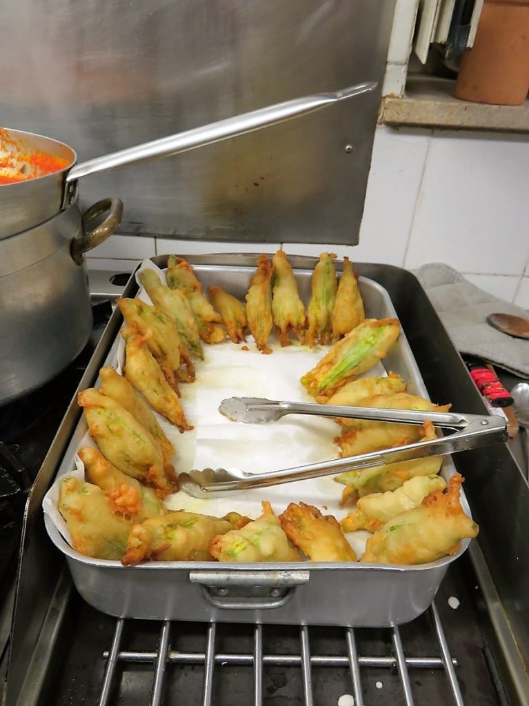 chicken breasts in orange sauce, fried zucchini blossoms ready to serve