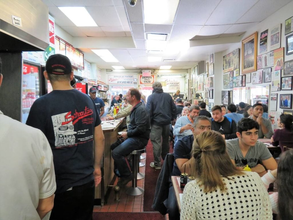 poutine with gluten free gravy; seated at the counter in Schwartz's Deli