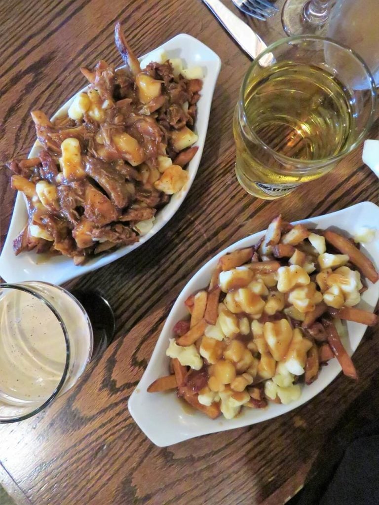 two dishes of Quebec poutine, one with rib meat