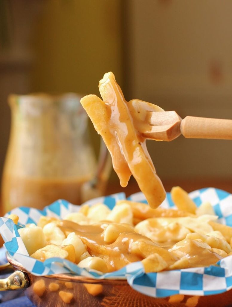a forkful of poutine with rich gluten free gravy