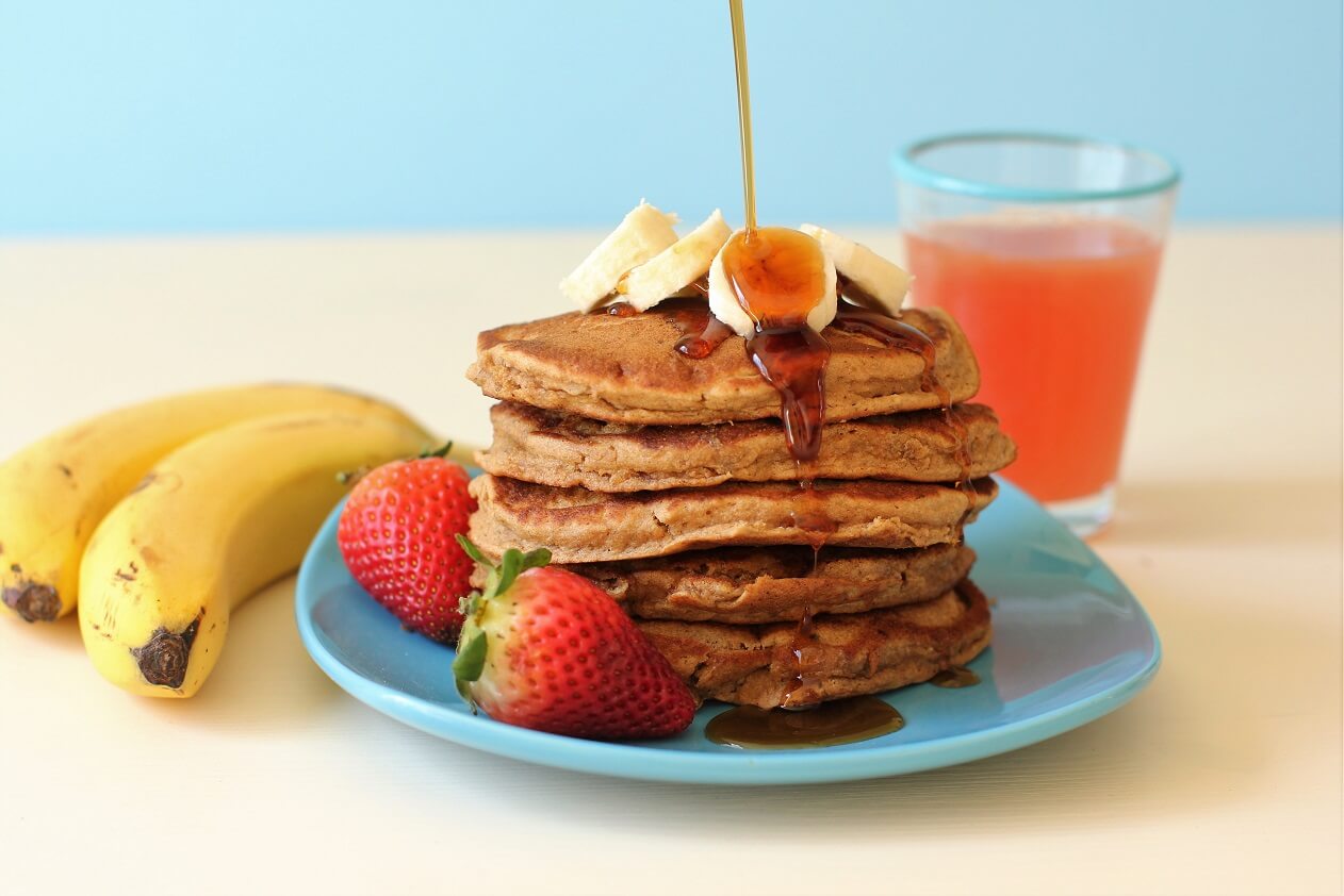 banana buckwheat pancakes with banana slices and maple syrup splash