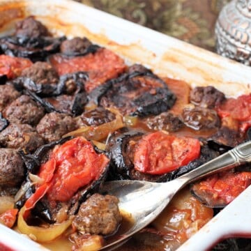 Iraqi comfort food dish - tepsi baytinijan is layers of eggplant, potatoes, tomatoes and meatballs