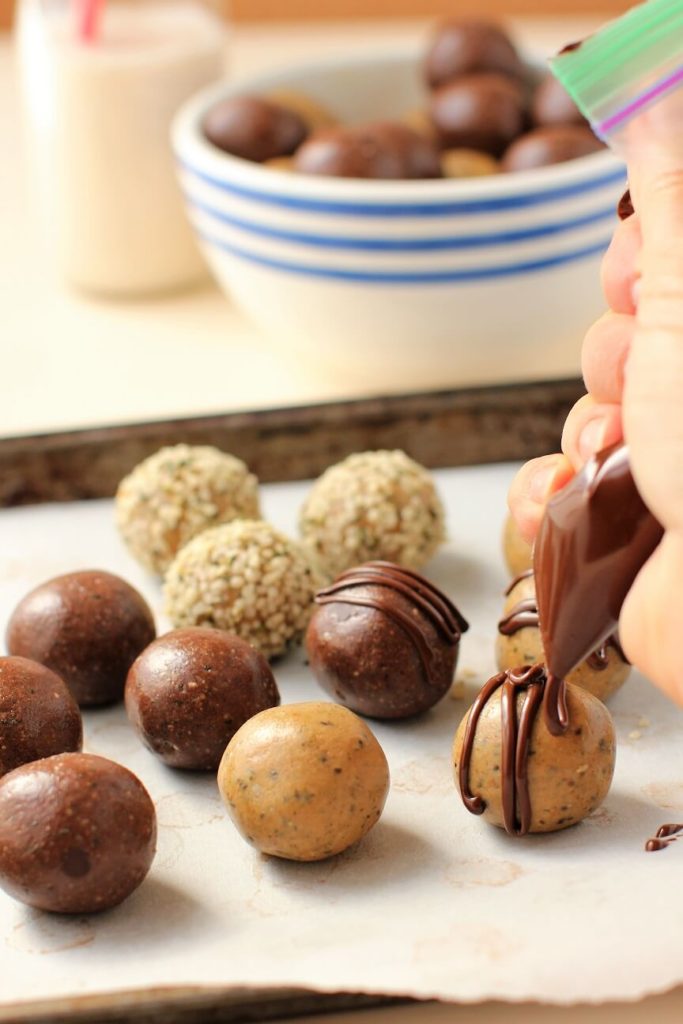piping chocolate glaze onto protein balls
