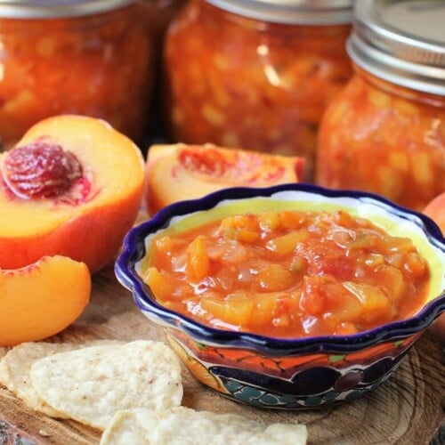 jars of canned peach salsa and a bowl of it in front of them