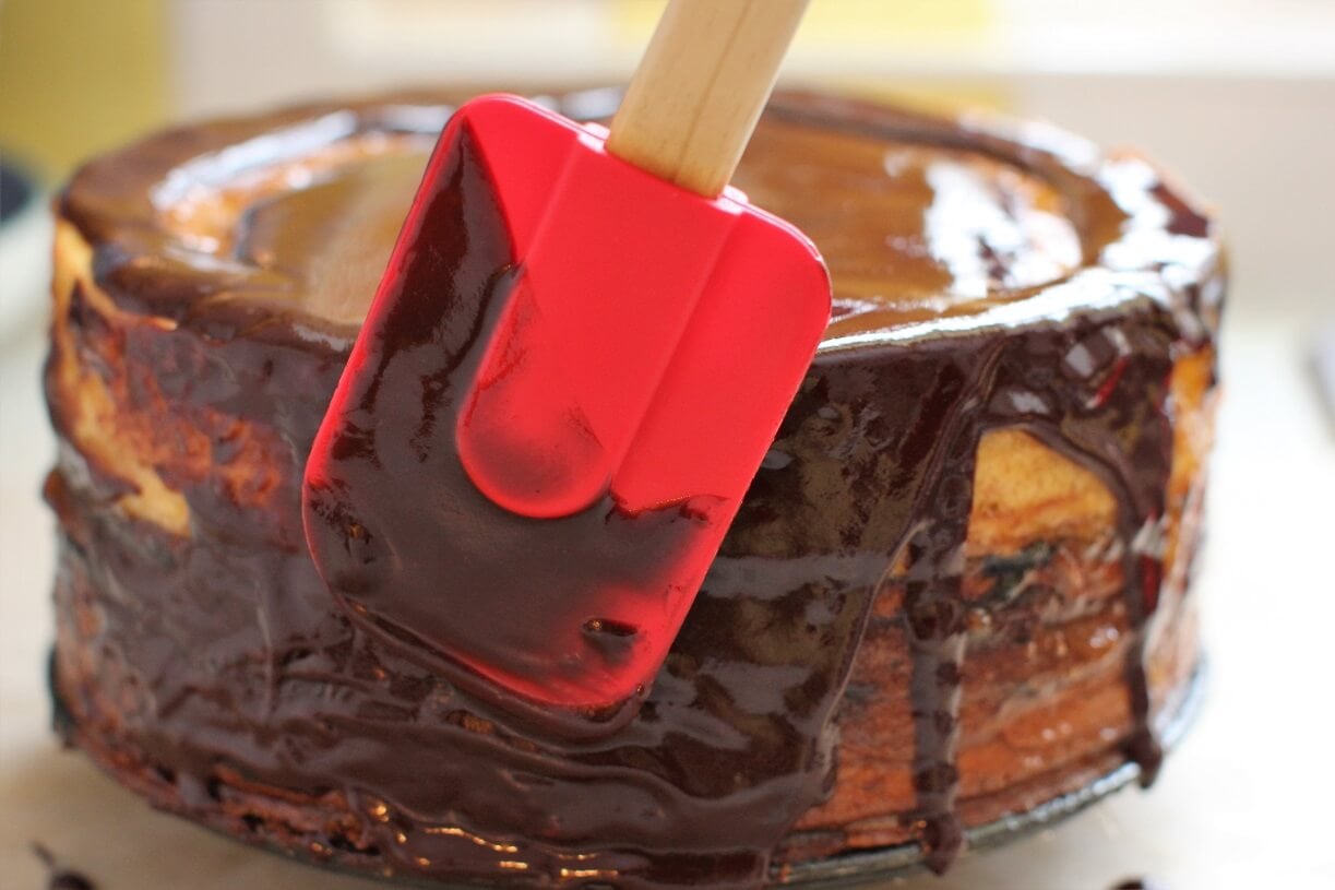 spreading the chocolate glaze on the cake
