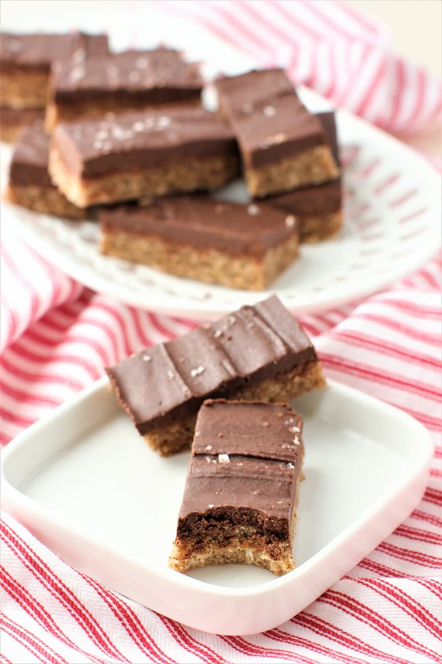 two chocolate almond bars on a plate, bite out of one