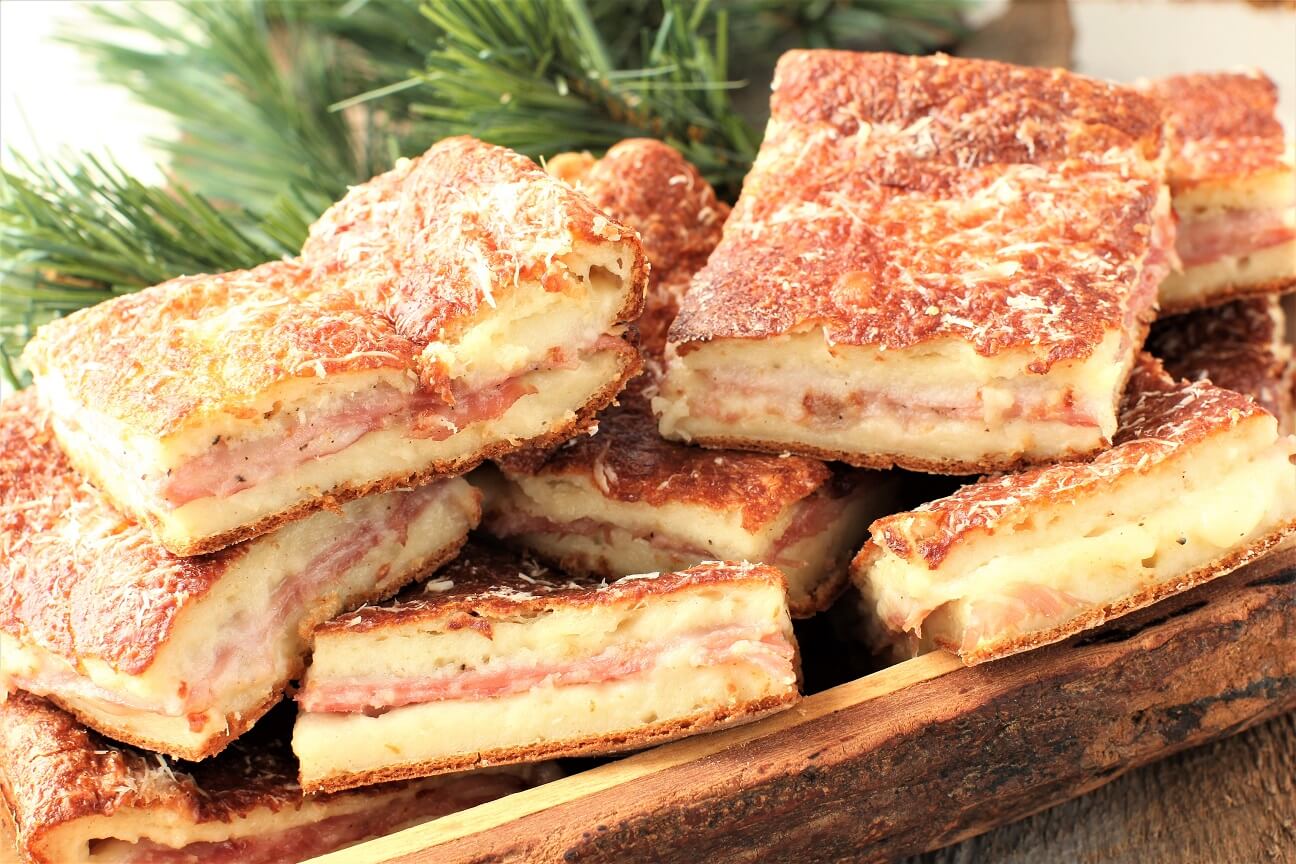 wooden bowl of baked ham & cheese sandwiches