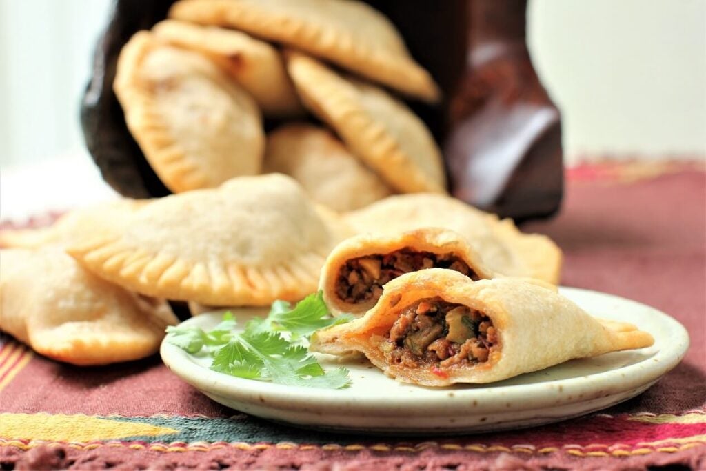 cassava empanadas on the table, and one cut open to see the inside