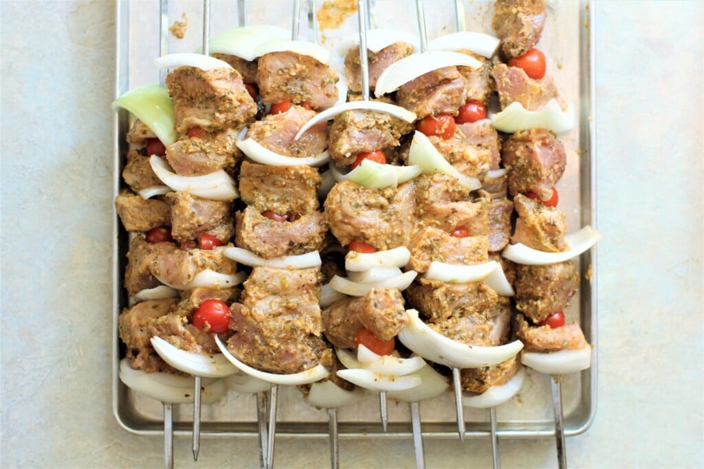 marinated meat on skewers with onions and tomatoes