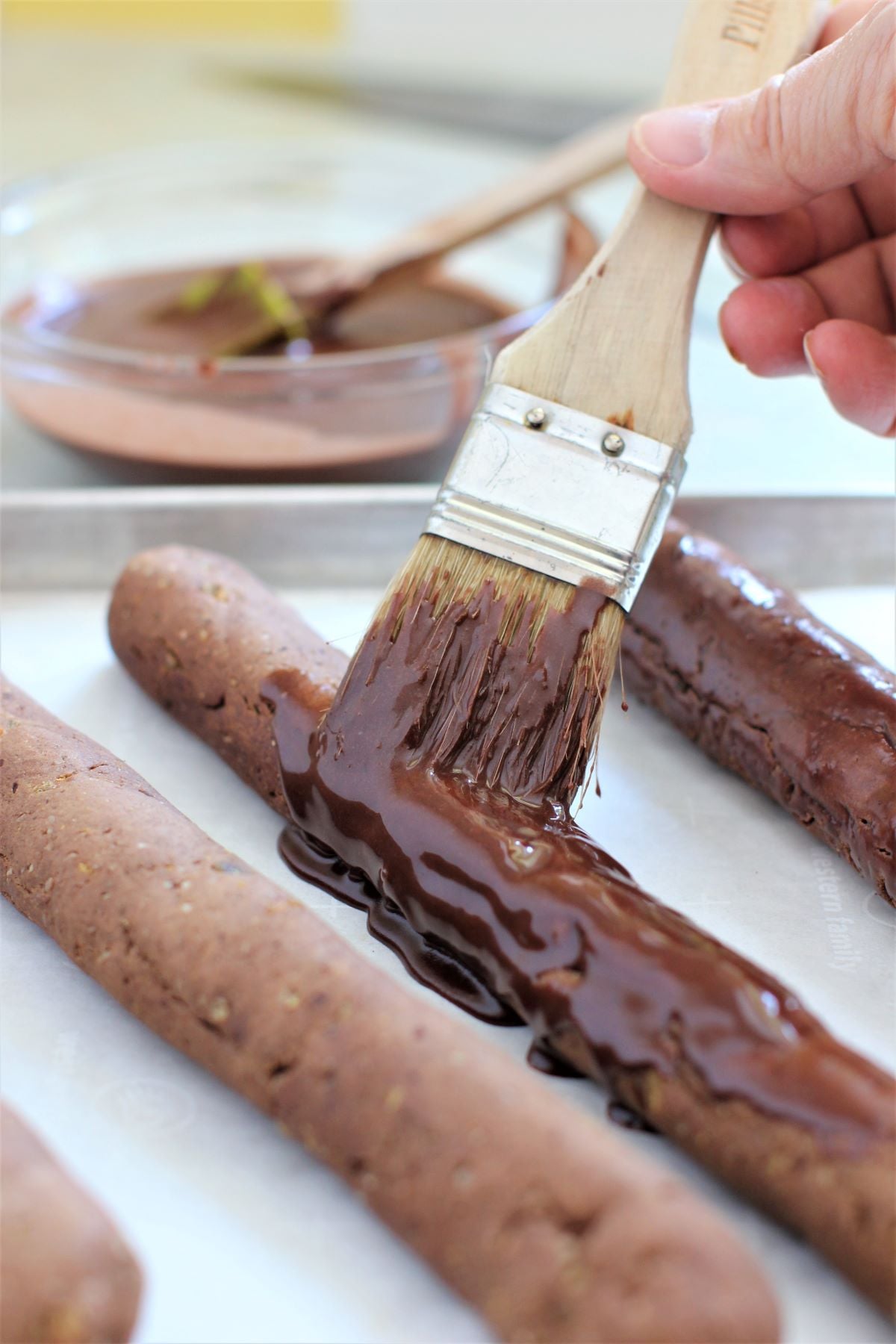 brushing the baked strips of dough with chocolate icing.