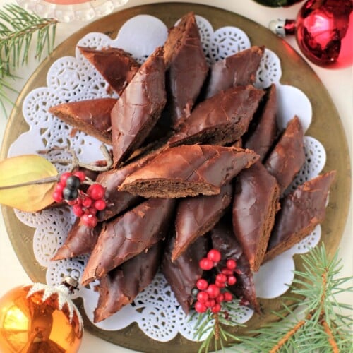 thumbnail top-down view of a plate of Magenbrot diamonds on a lace doily on a plate with Christmas balls around.