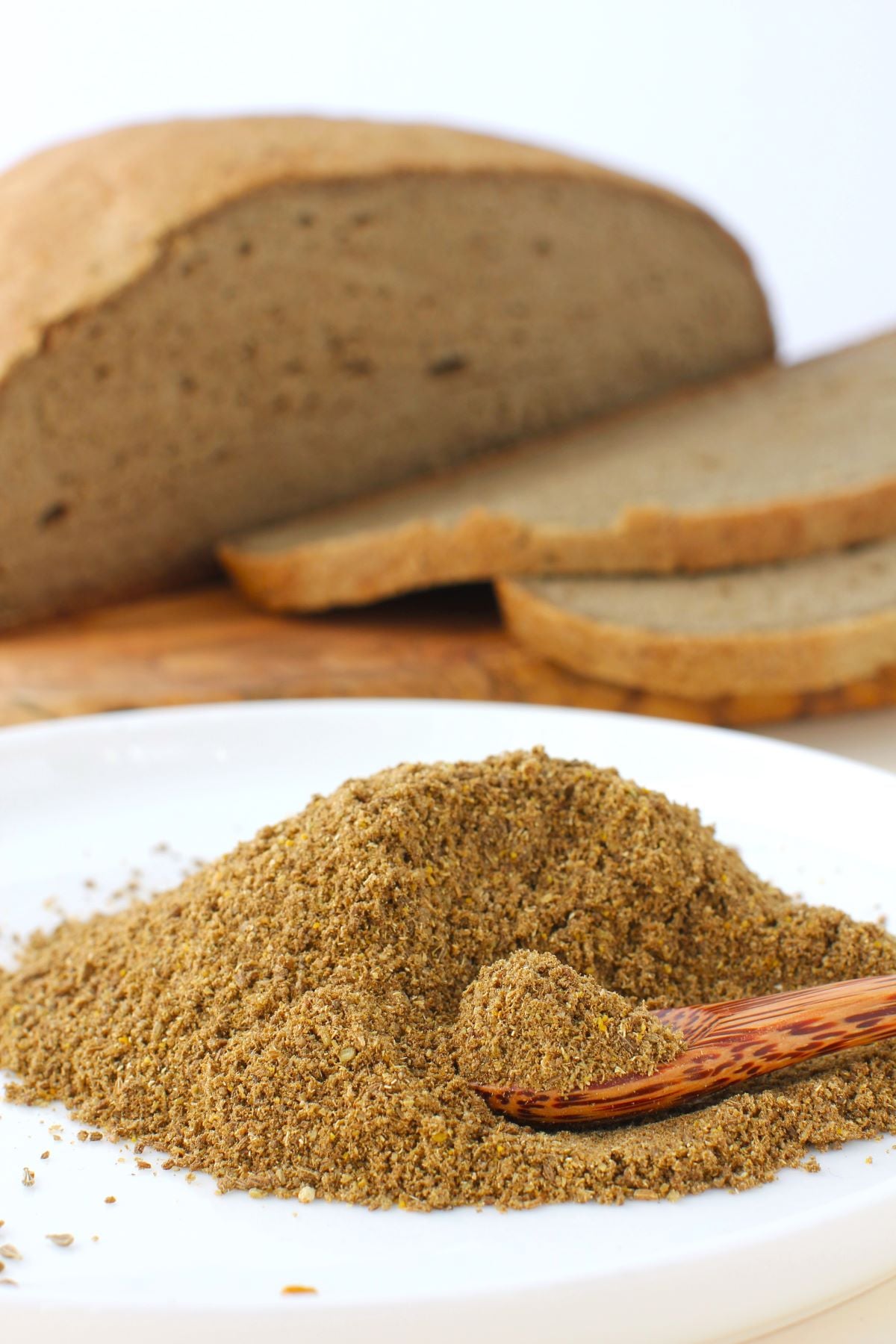 mound of bread spice with sliced loaf of homemade deli-style bread behind.