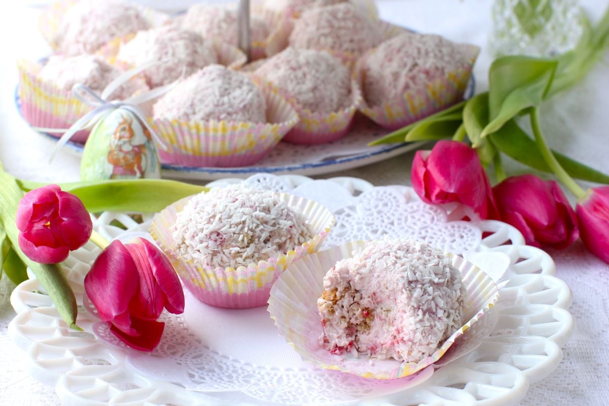 2 Raspberry Snowballs on a plate, with pink tulips laid beside.