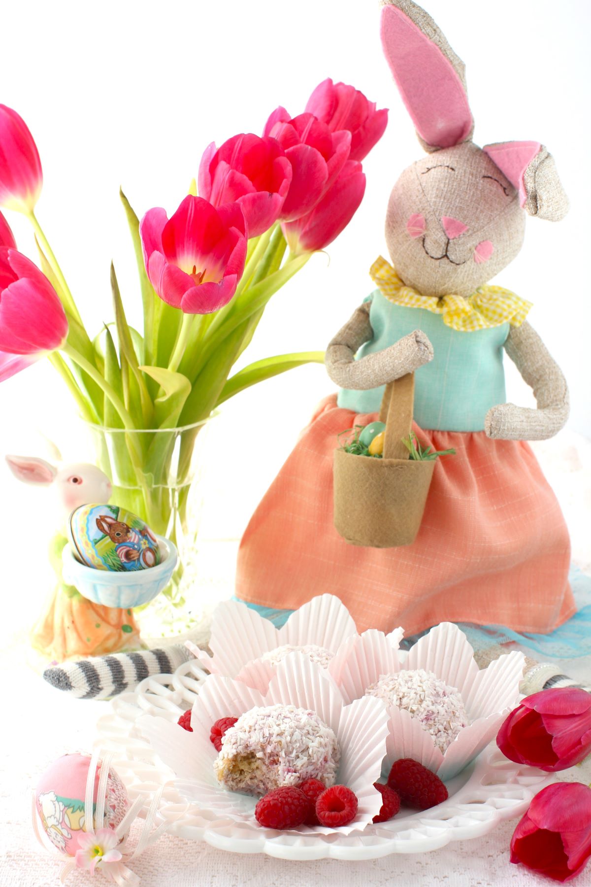 Schneeballen on a plate, with vase of tulips behind and an Easter bunny.