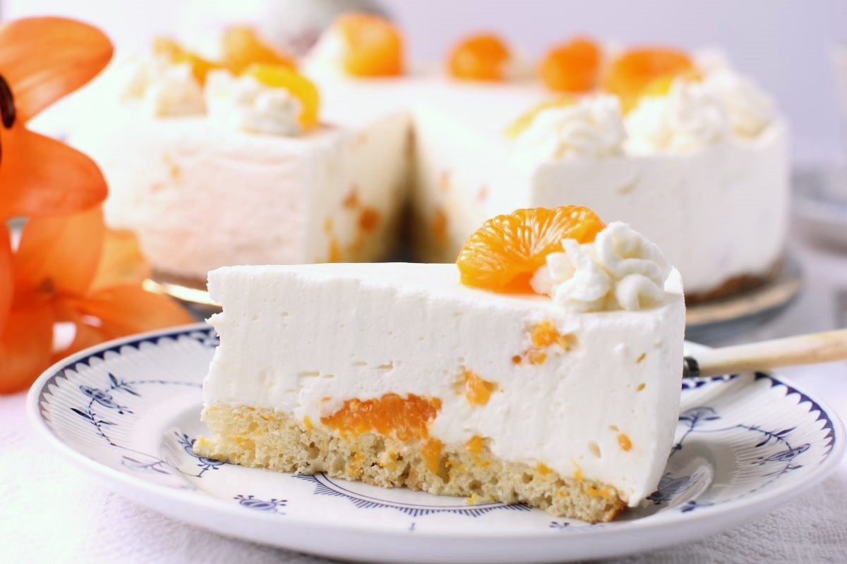 A slice of the Mandarin Cream Torte on a blue and white plate.