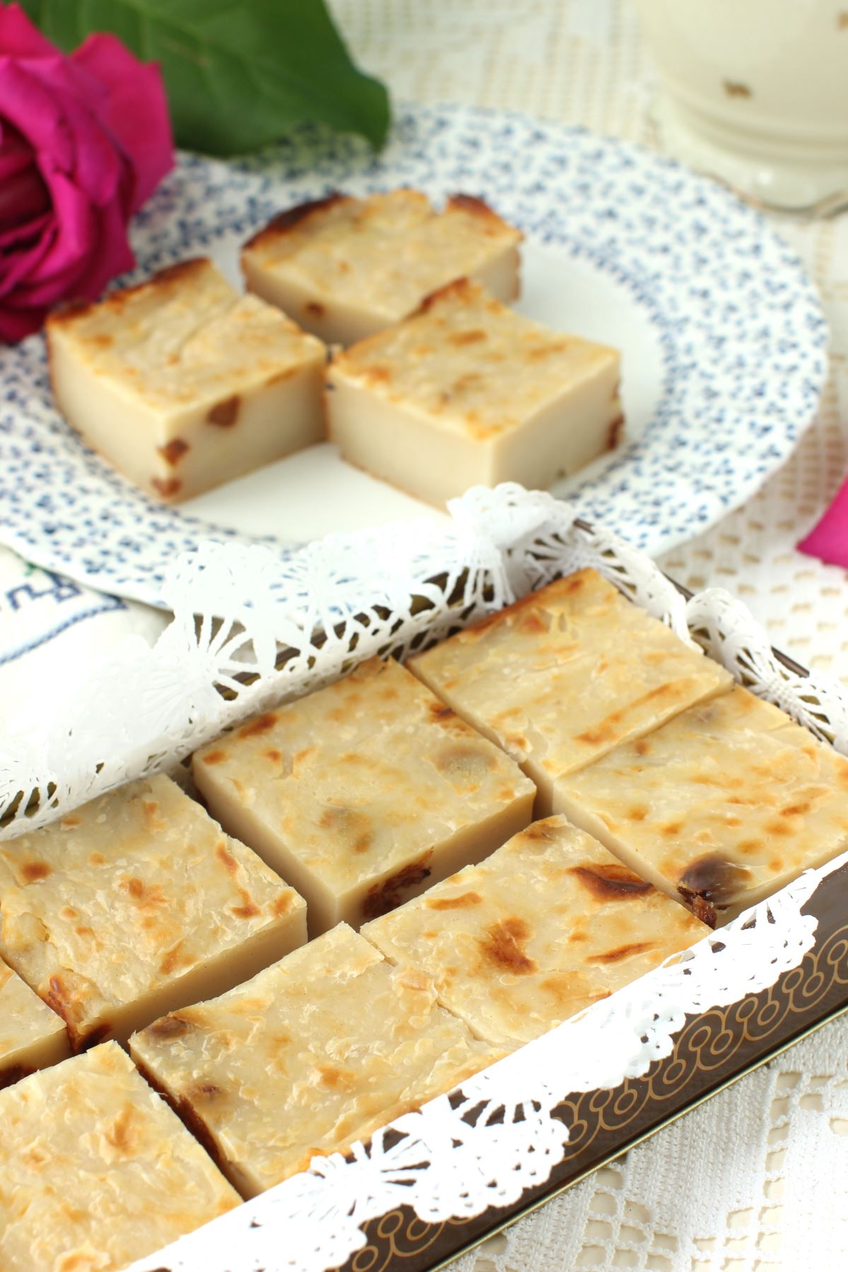 Squares of the Tamal de Maicena in a tin box lined with paper doily.