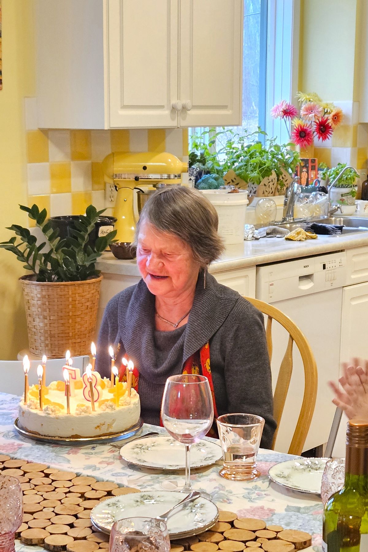Mom ready to blow out the candles on her Mandarinen Sahnetorte Cream torte for her 87th birthday.