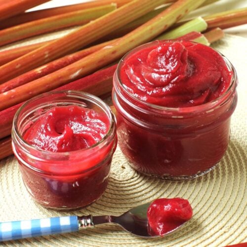 Square photo of two jars of rhubarb butter with a spoonful of it laying in front.