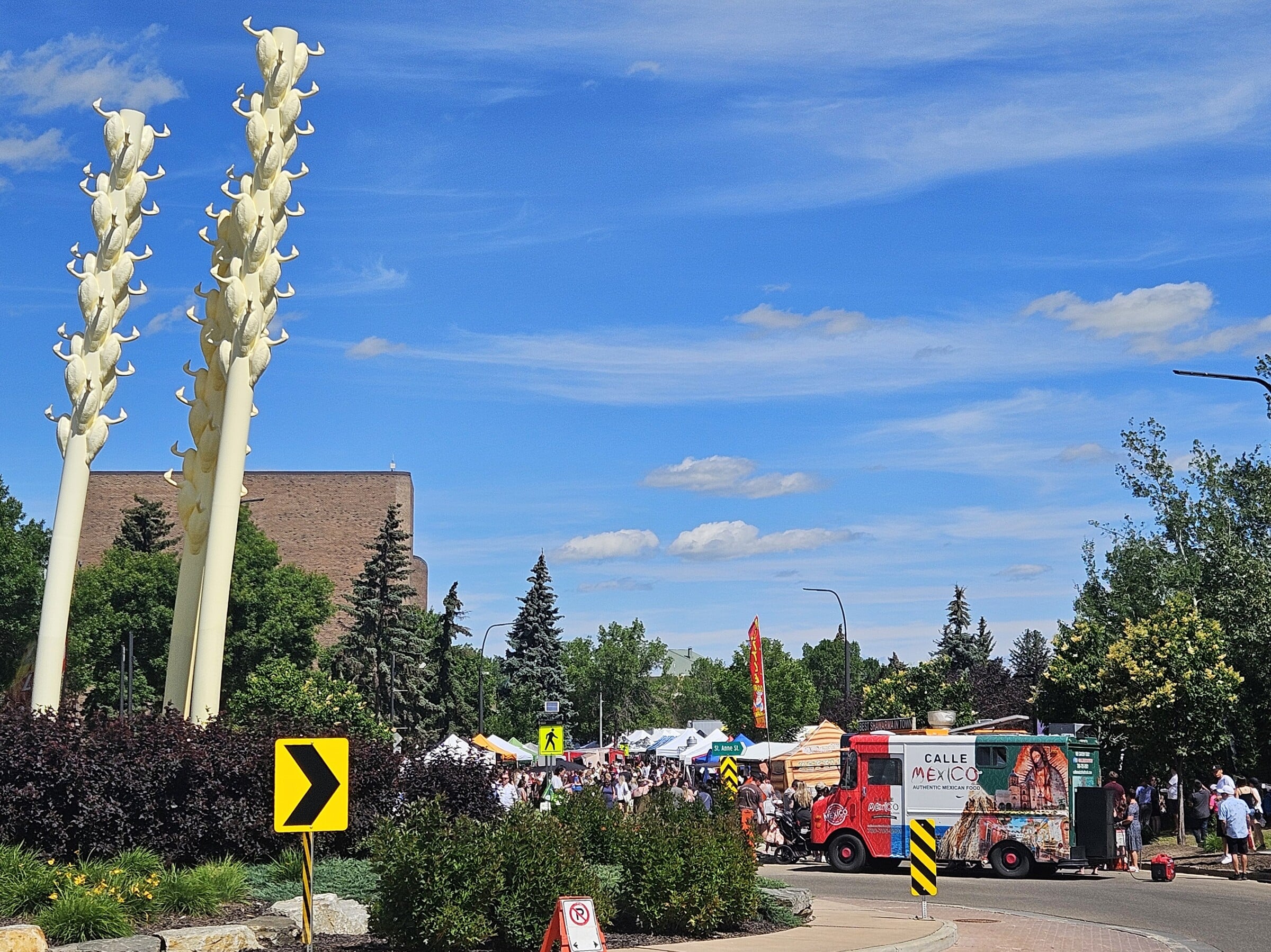 Three slanted yellow poles with geese statues on them mark one end of the market.