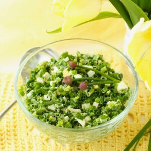 Square thumbnail photo of clear glass bowl with chive salad, on a yellow background.