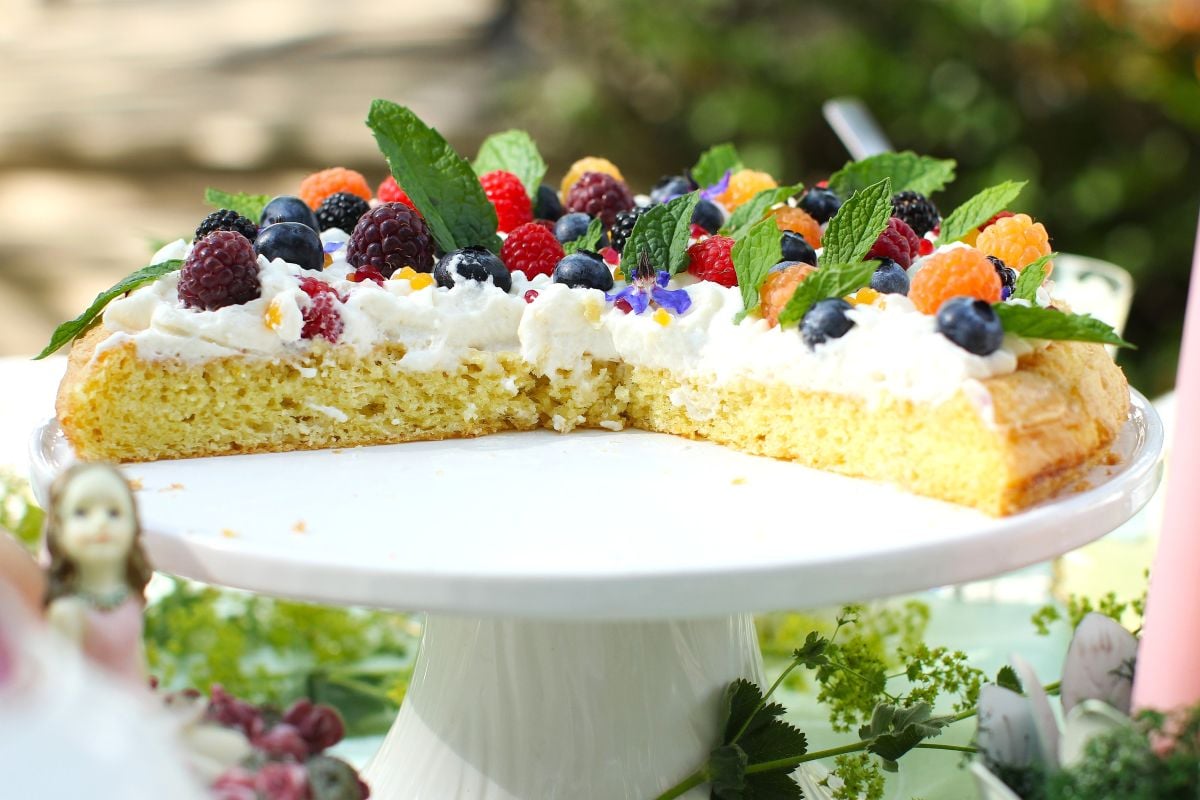 Half of an almond cake left on the cake stand.