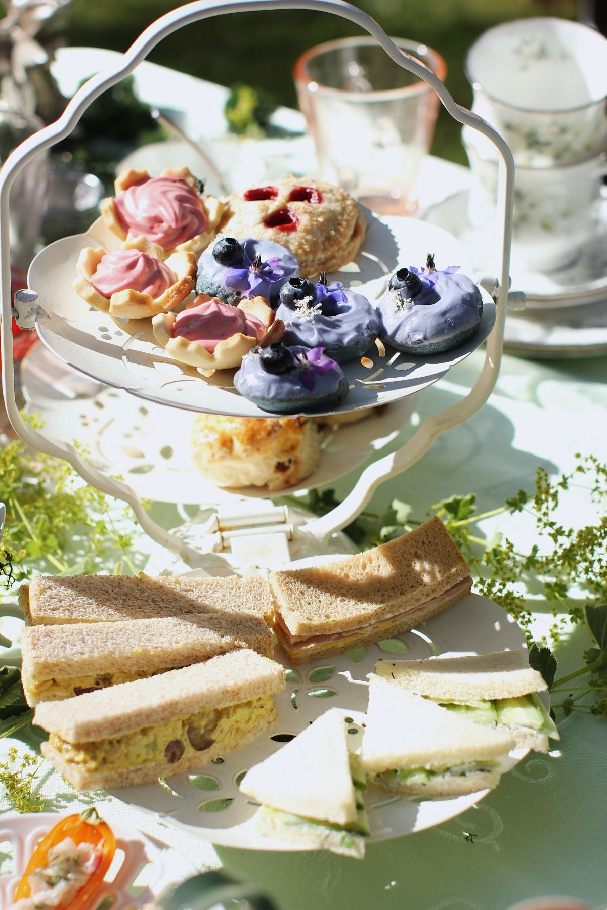 a 3-tiered stand loaded with finger sandwiches, scones, and sweet treats.