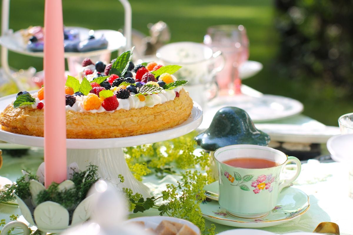 Almond Cake on a footed cake stand on that table amidst the tea things.