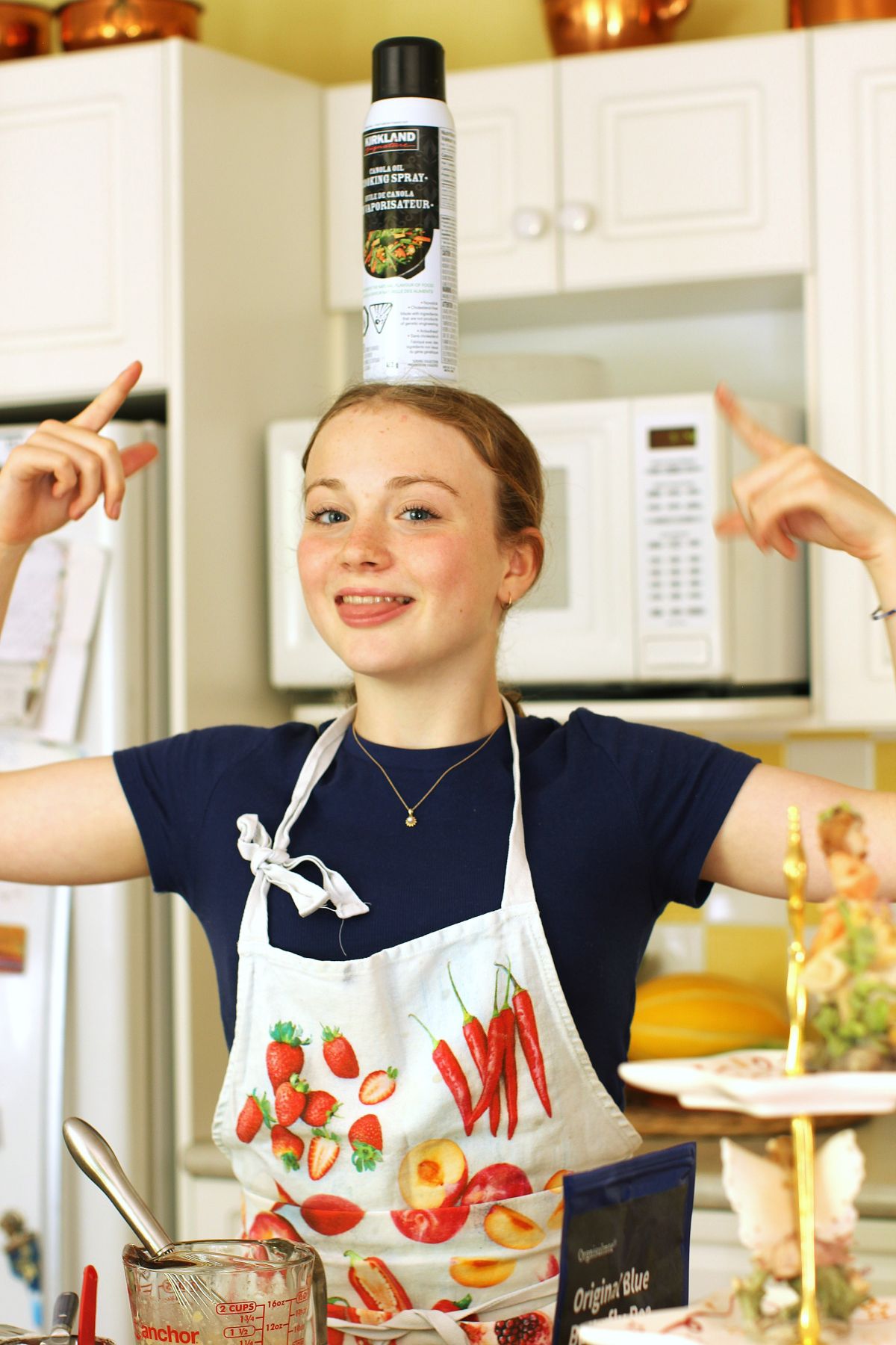 Amelia clowning around with the can of baking spray balanced on her head.
