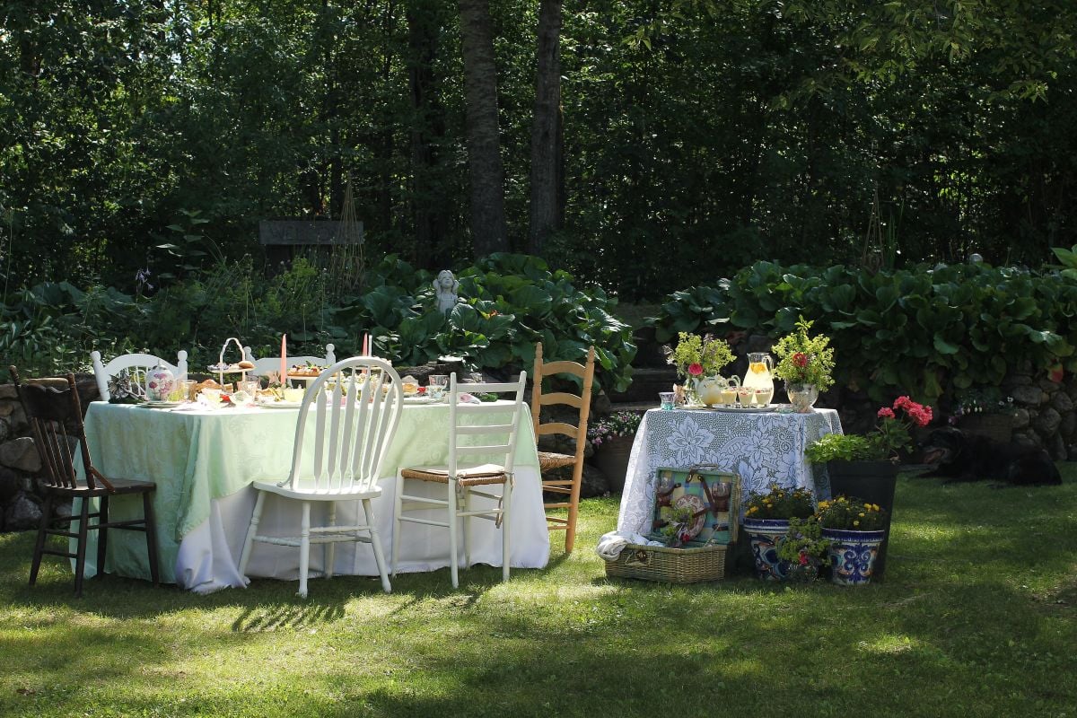 The table set outside against the rock wall for the fairy picnic, with a side table for drinks and desssert.