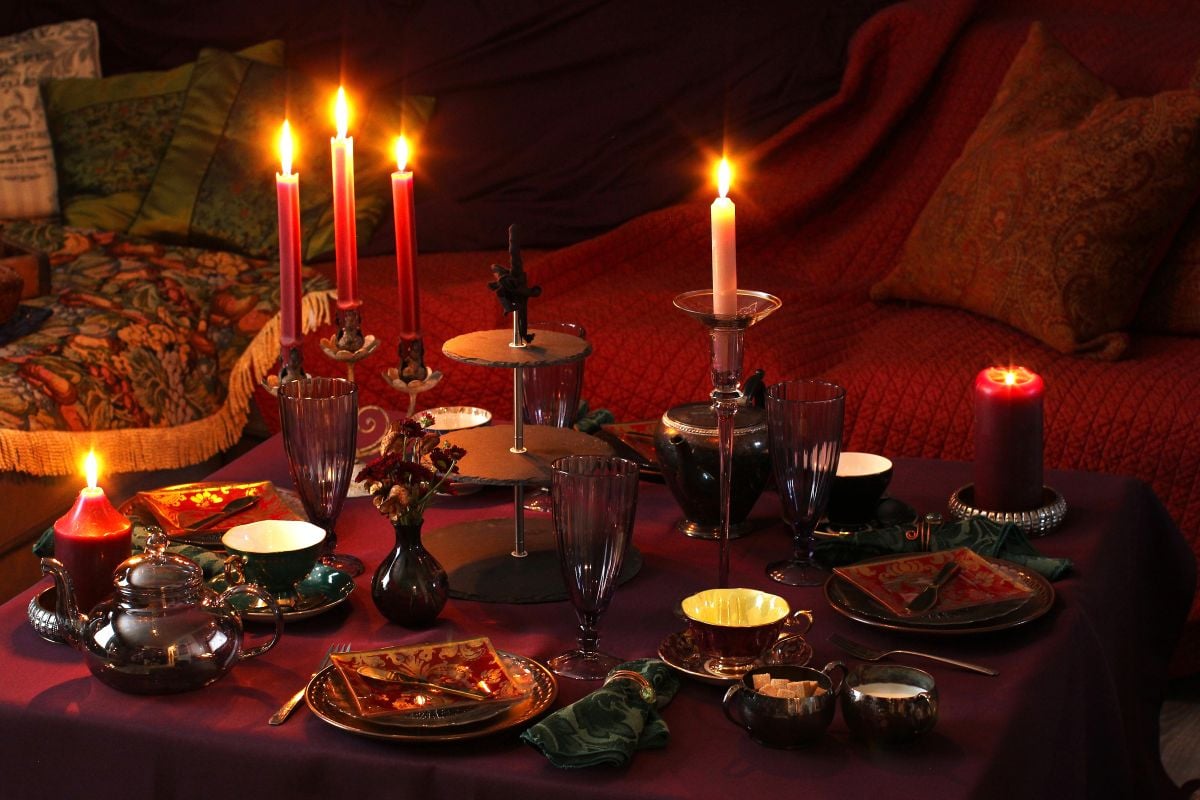 The table is set and candles lit for the moody magic afternoon tea party.