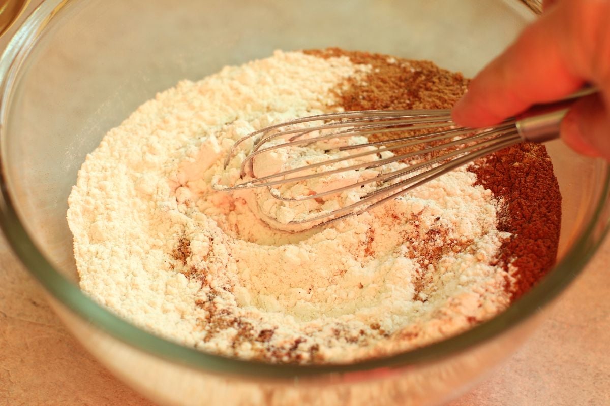 Whisking the dry ingredients in a clear glass bowl.