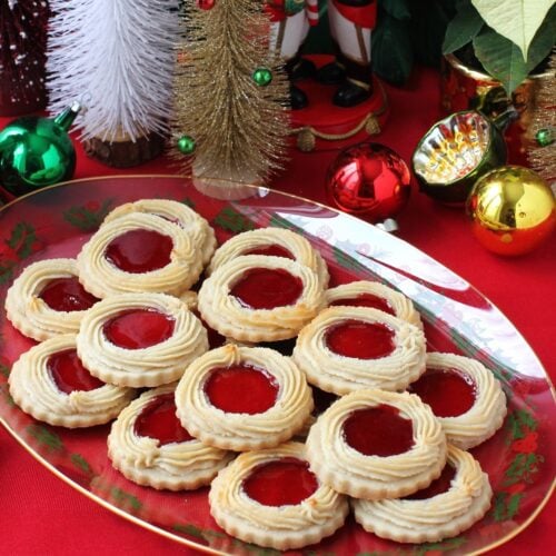 Thumbnail photo of a Christmas platter of Marzipan Kränze (German wreath cookies) with Christmas balls in the background.