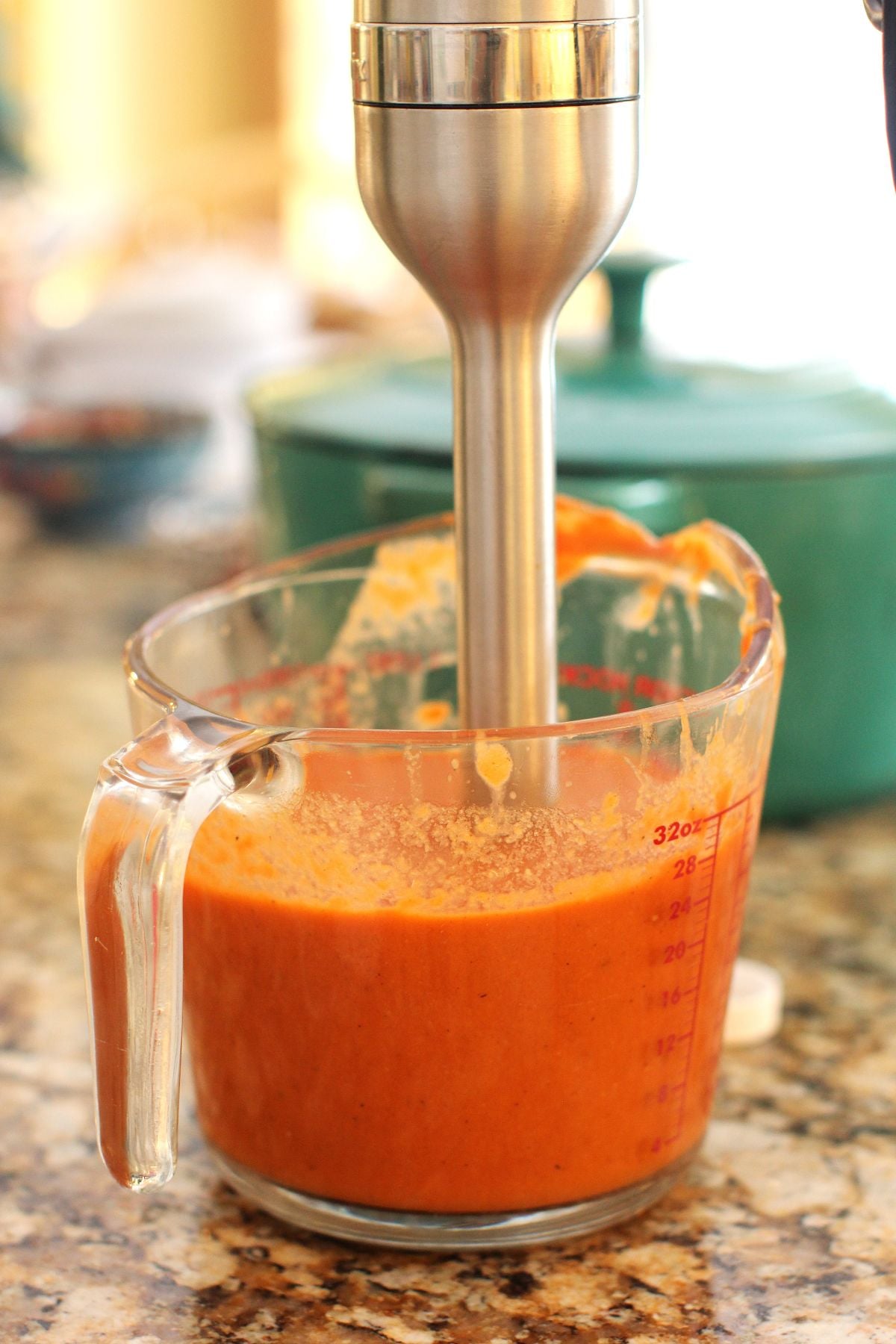 Whizzing the tomato sauce for koshari in a measuring cup with an immersion blender.
