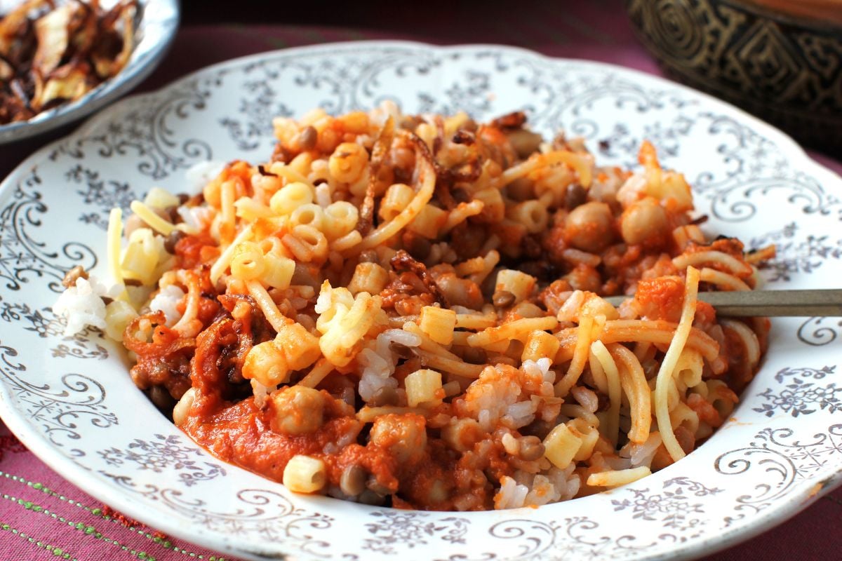 Closeup view of a plate of koshari stirred up to mix the ingredients - ready to eat.