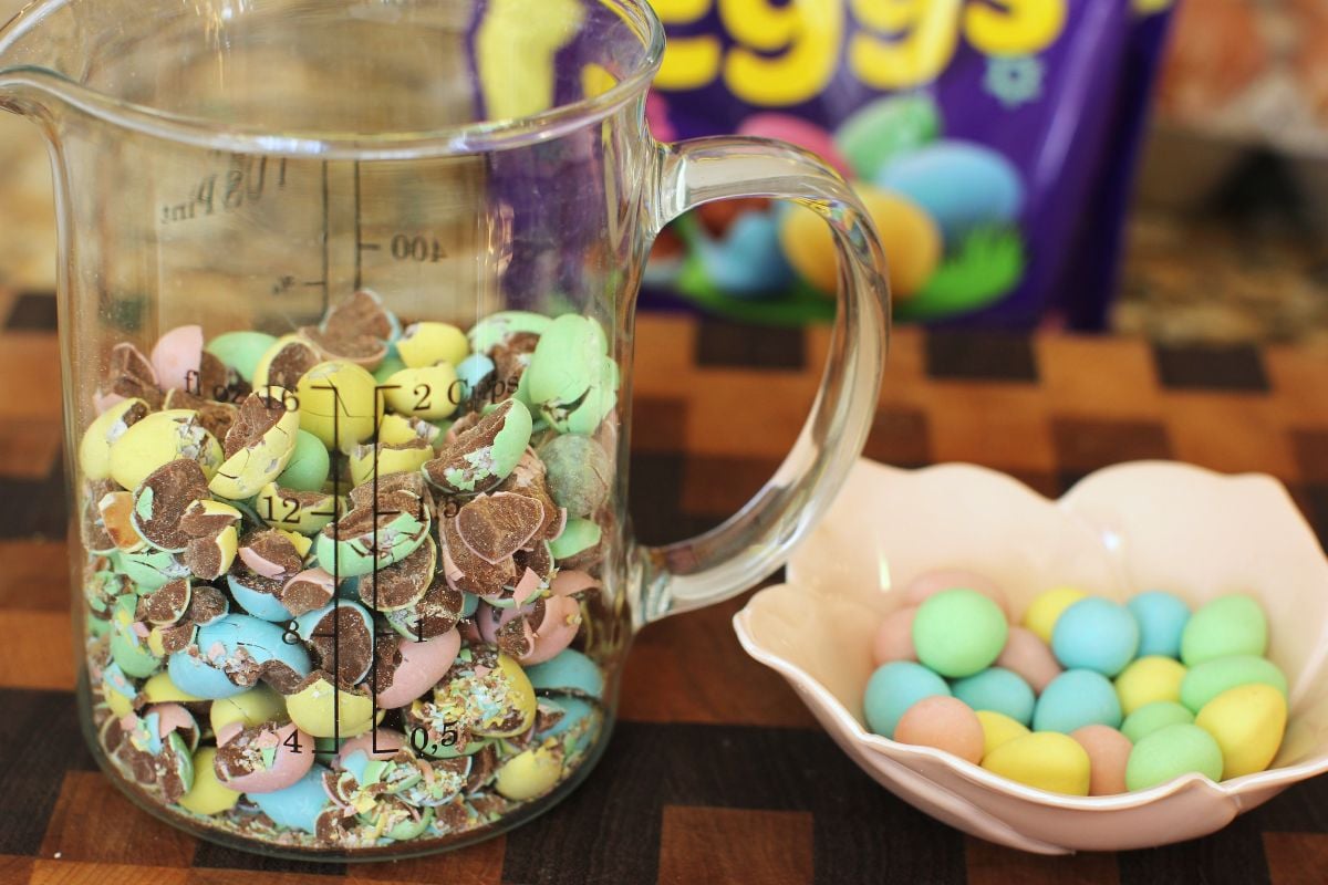 Measuring cup of cracked mini eggs and small bowl of whole ones to decorate the top of the bars.