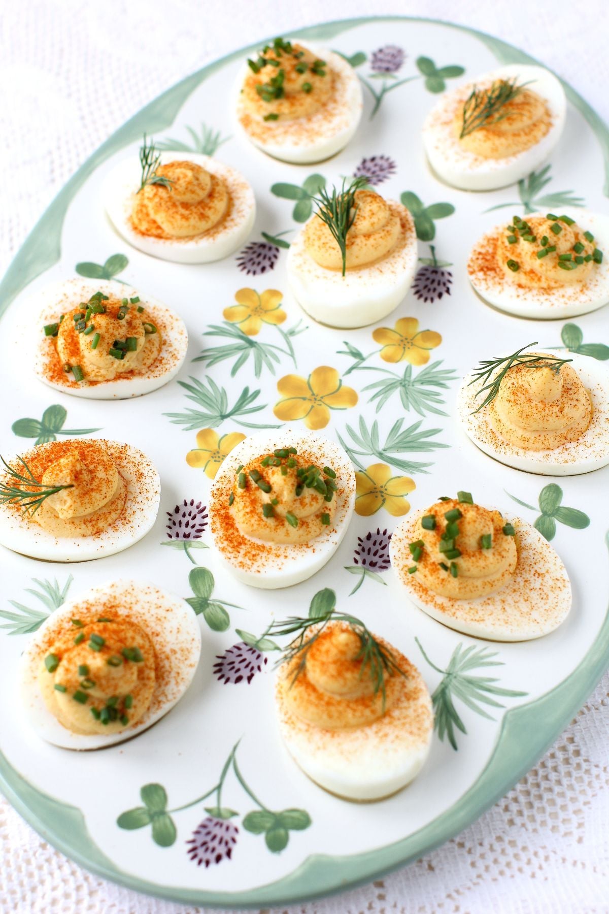 Flowered platter with green edge, filled with 12 deviled egg halves.