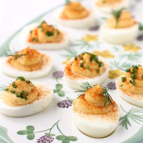 Close-up thumbnail of platter of deviled eggs, one with chopped chive garnish and one with dill sprig garnish.