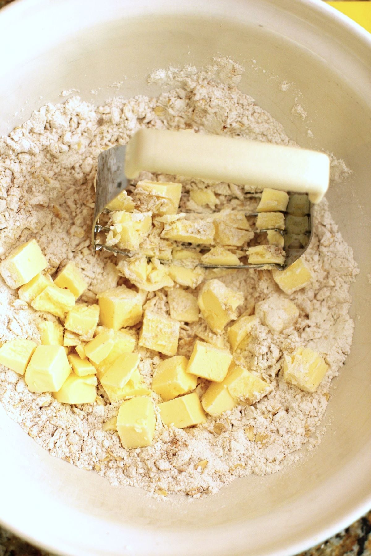cutting the butter into the dry ingredients with a pastry cutter in the mixing bowl.