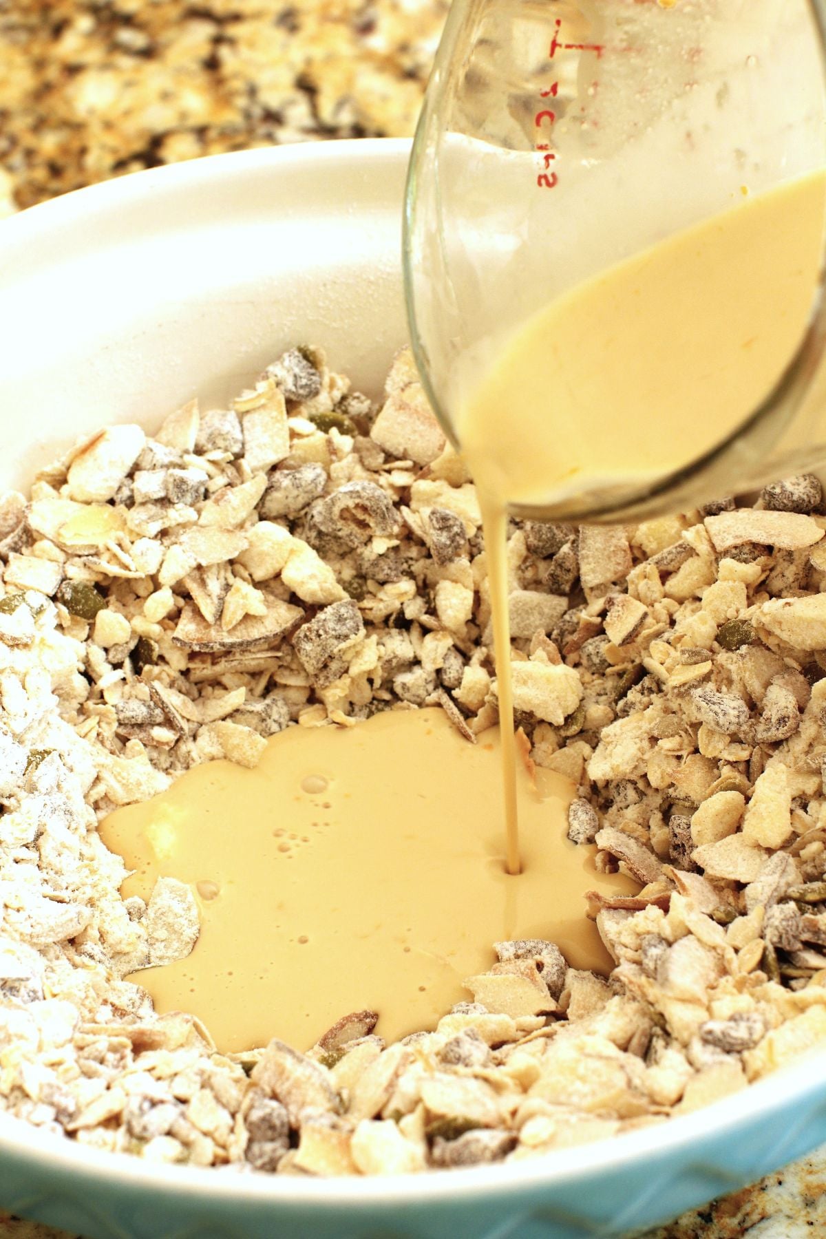 Pouring the liquid ingredients into the dry in the bowl for the granola scones.