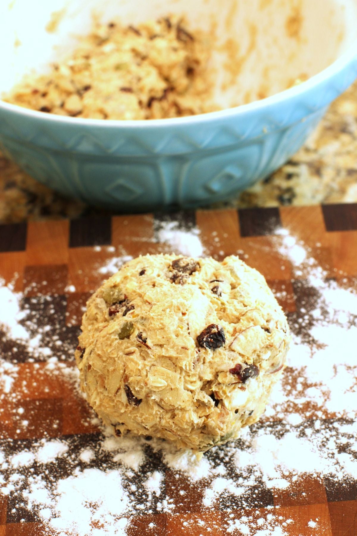 a ball of scone dough on the cutting board in front of a blue bowl.