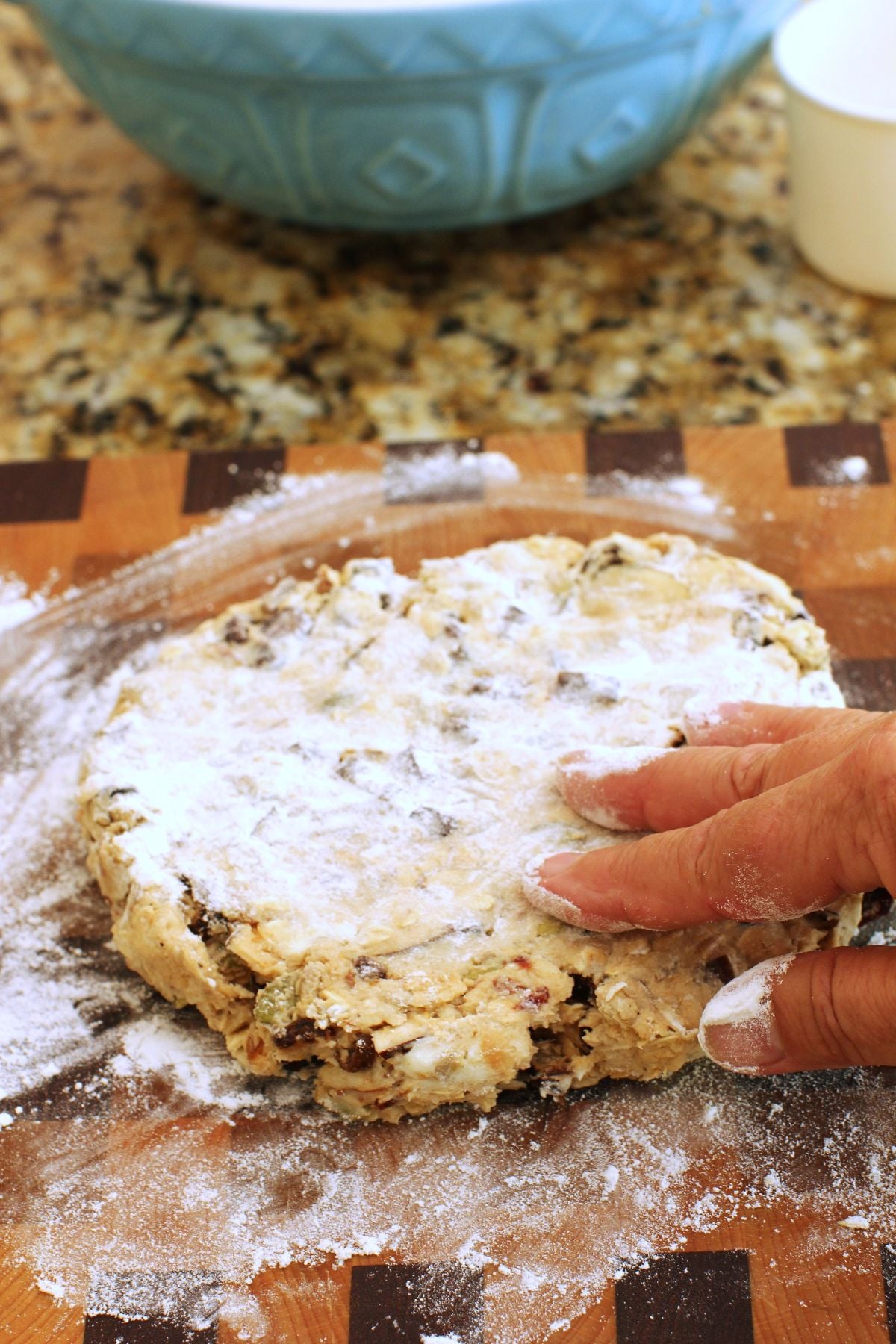 disc of dough with fingers flattening it.