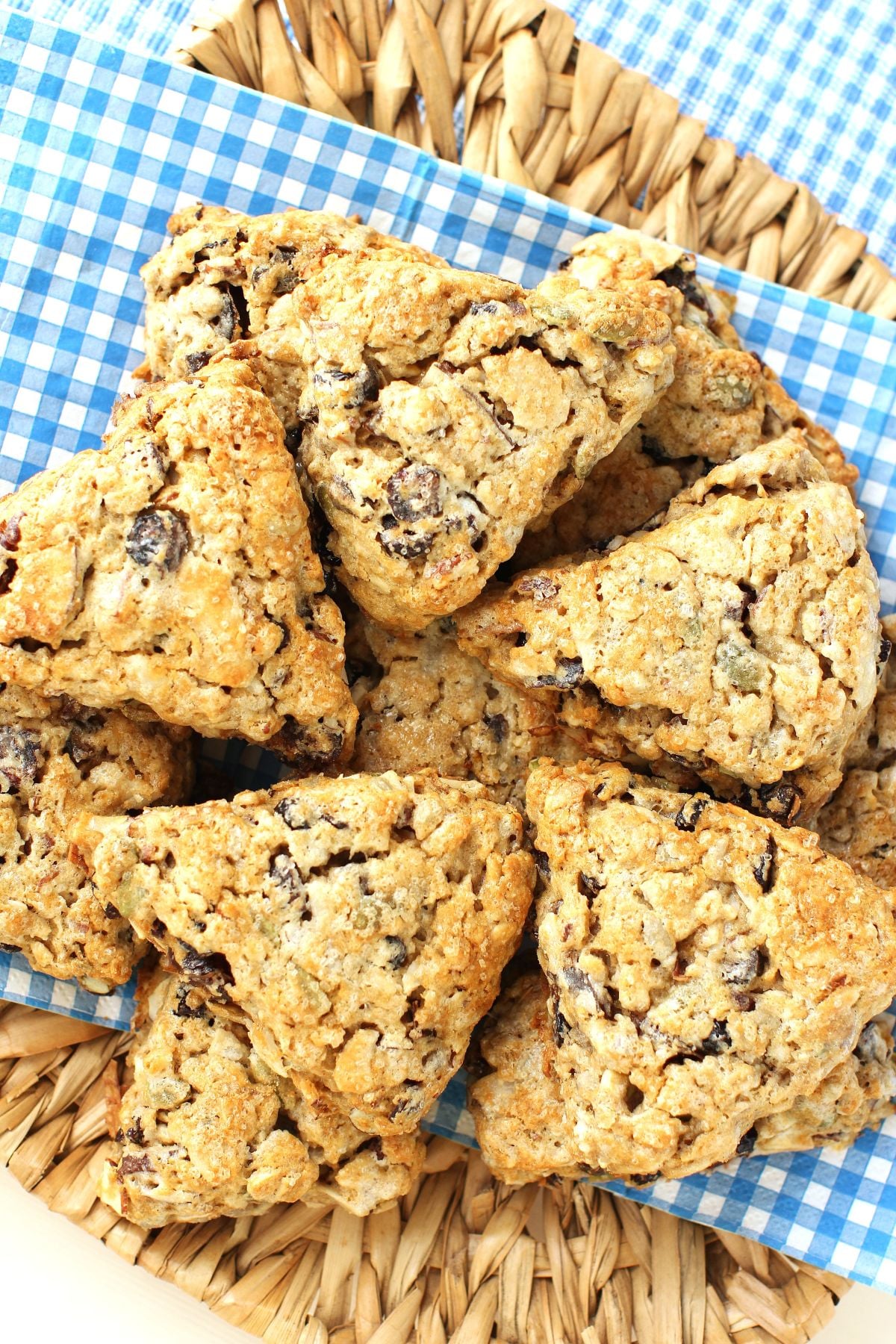 A pile of granola scones on a blue and white napkin on a seagrass tray.