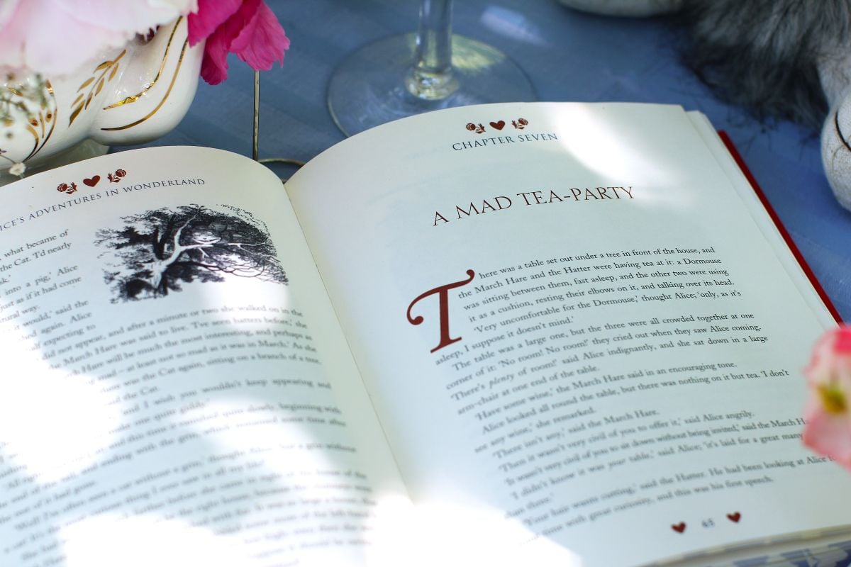 Lewis Carroll's 'Alice's Adventures in Wonderland' book open to Chapter Seven page, "A Mad Tea-Party'.