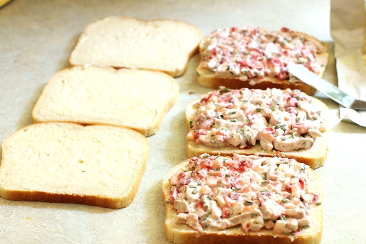 3 slices of buttered white bread and 3 slices spread with strawberry chicken salad.