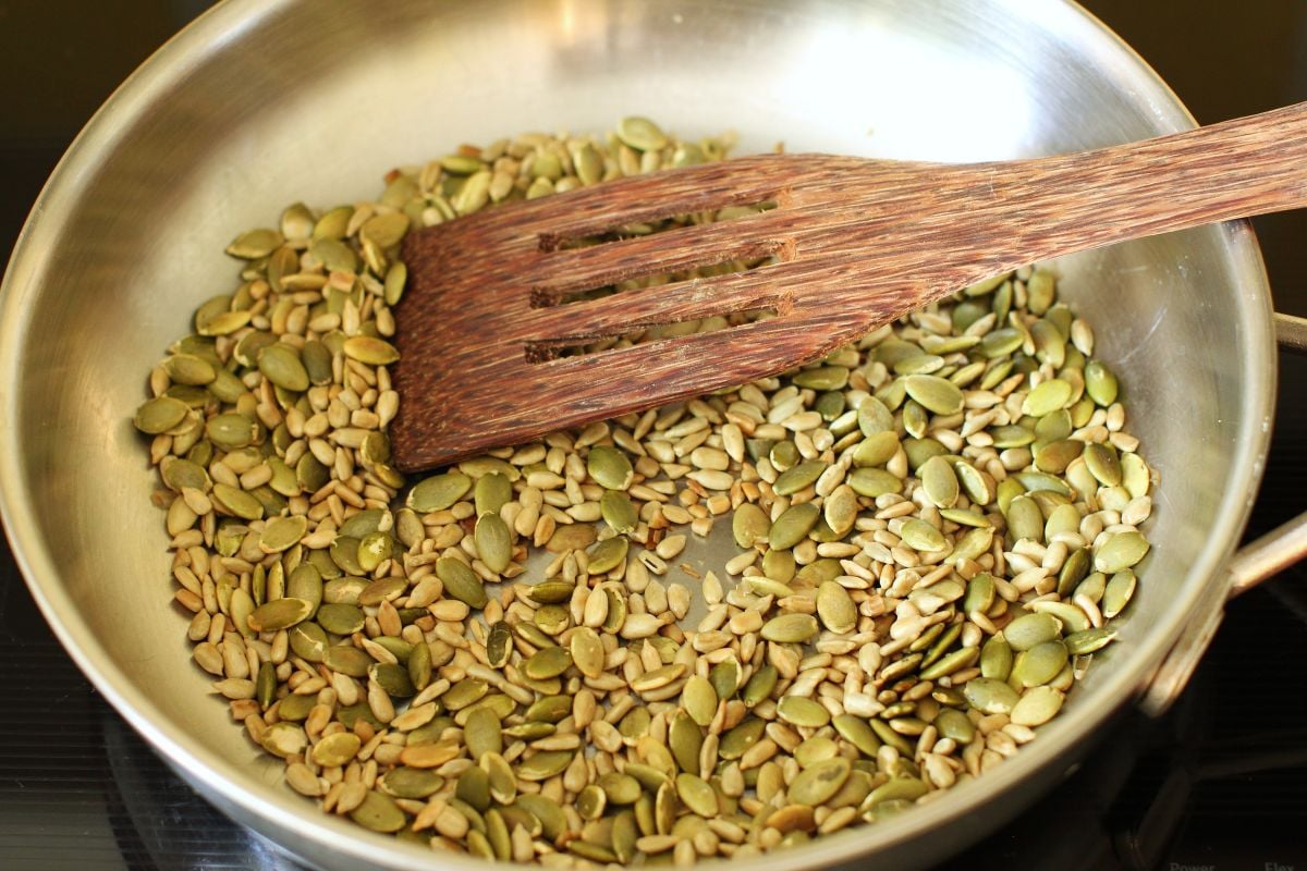 Toasting the pumpkin seeds and sunflower seeds in a stainless steel skillet.
