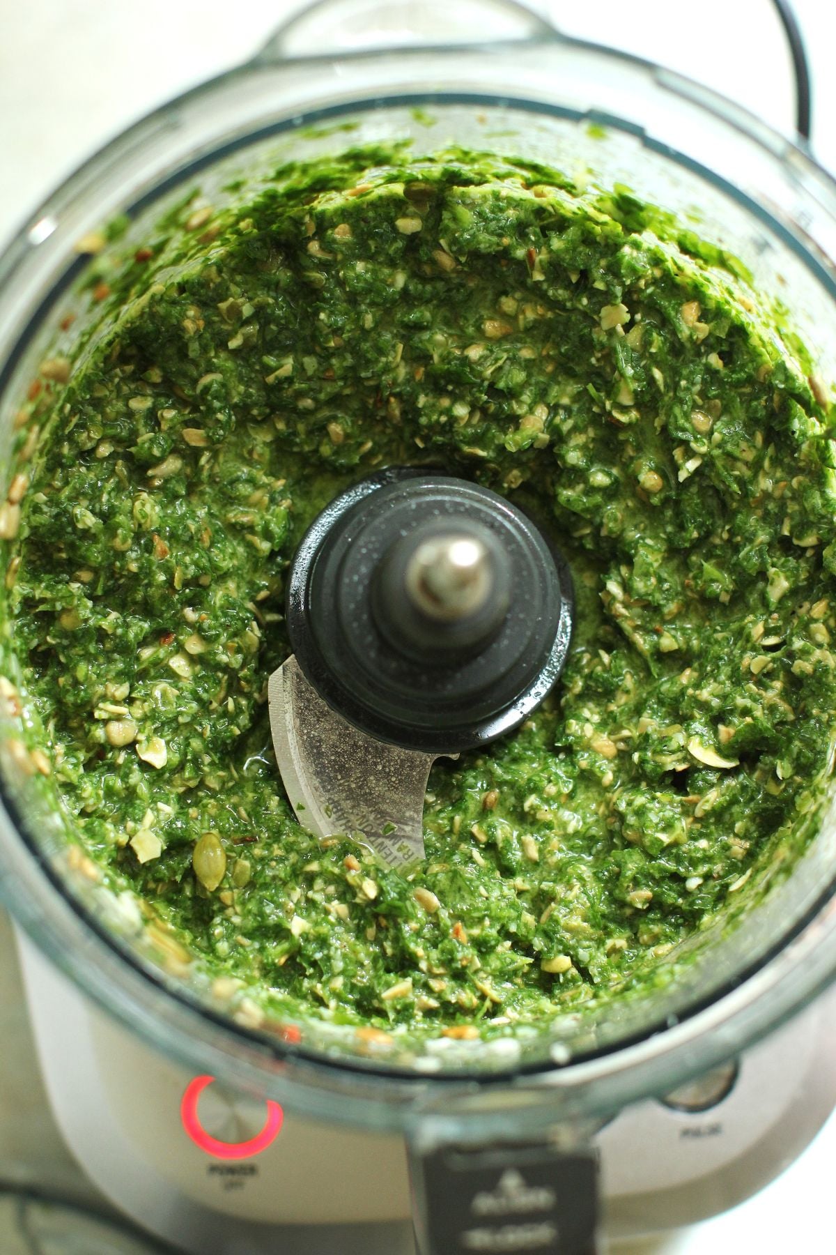 Looking down into the food processor canister to see the chunky sorrel pesto with seeds added.