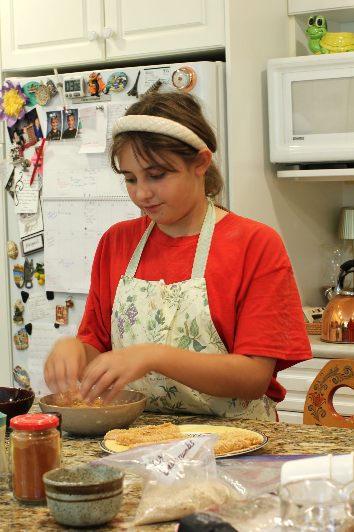 Willow dipping the chicken in the breadcrumbs.
