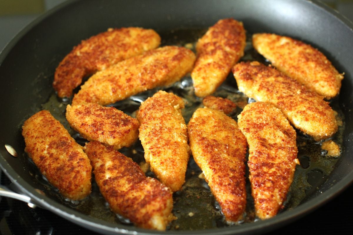 Cheesy Chicken Fingers frying in the skillet.